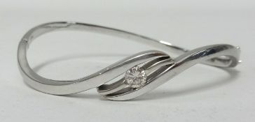 A 18ct white gold and diamond set bangle of contemporary twist style, approx 19.6gms.