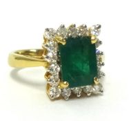 An 18ct fine emerald and diamond ring cluster ring, the oblong step cut emerald approx 2.60cts,