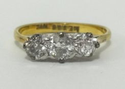 A diamond three stone ring, indistinct hallmark, probably 18ct, finger size O.