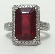 A 14k white gold and diamond ring set with an emerald cut ruby approx 6.19cts, diamonds approx 0.