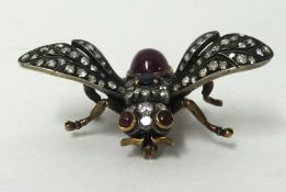 A fine antique insect brooch set with a cabochon ruby, a sapphire and old cut diamonds, wing span
