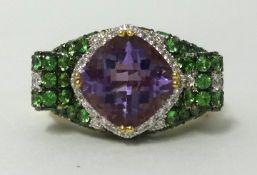 An 18ct amethyst, diamond and green garnet set dress ring, finger size O.