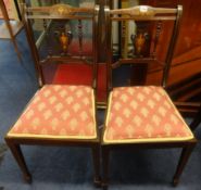 An Edwardian set of four mahogany and inlaid dining chairs.