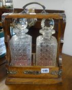 A two bottle Tantalus in a oak and silver plated mounted case.