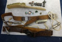 A collection of boy scout and girl guide belts with lanyards, penknives and whistles.