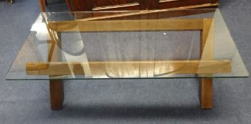A modern glass top coffee table with x framed base.
