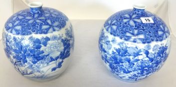 A pair of Japanese blue and white squat porcelain jars decorated with flowers.