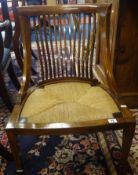 A Edwardian mahogany inlaid nursing chair with rush seat and square tapered legs.