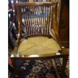 A Edwardian mahogany inlaid nursing chair with rush seat and square tapered legs.