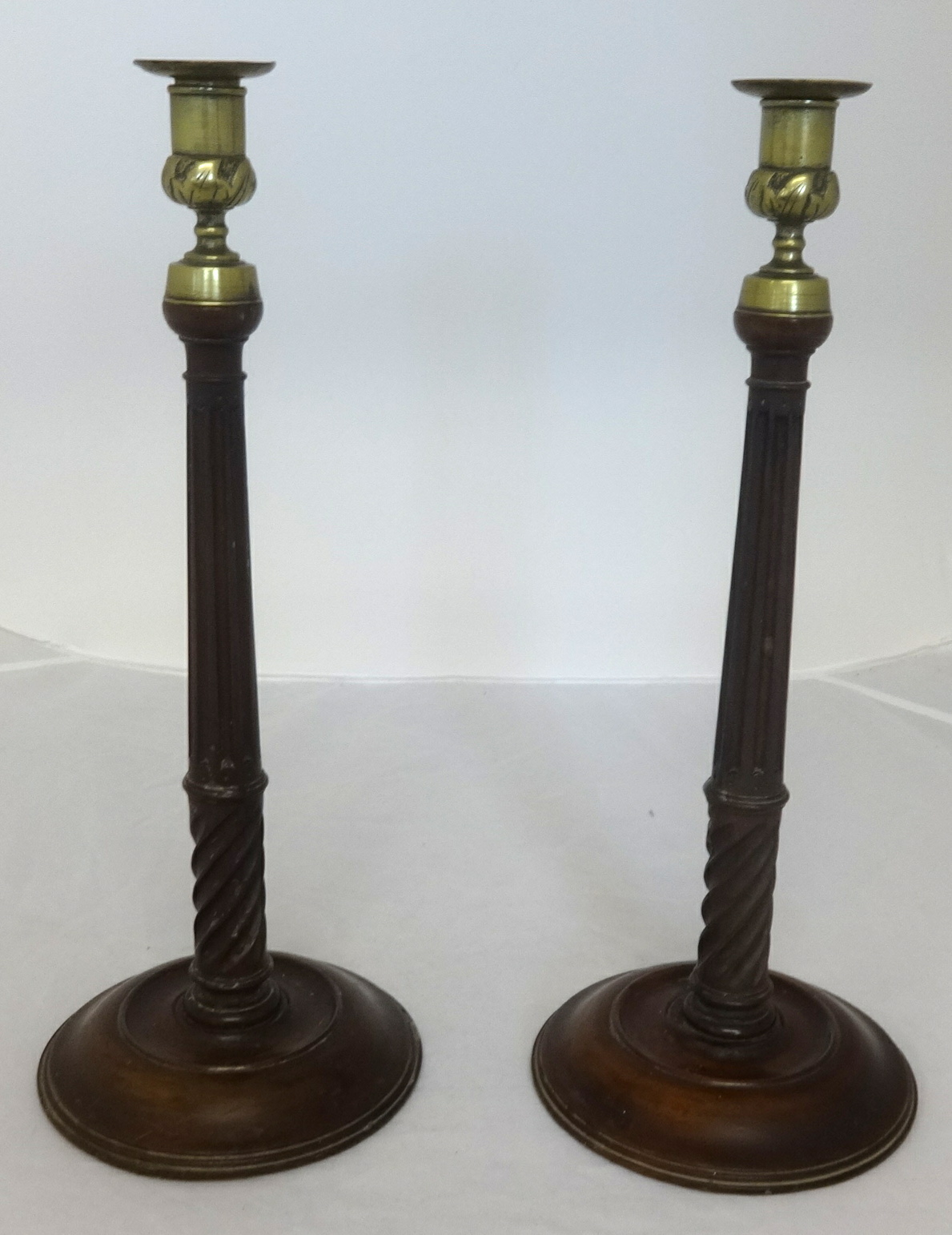 A pair of 19th Century carved wood candlesticks with brass sconces, height 38cm.