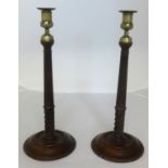 A pair of 19th Century carved wood candlesticks with brass sconces, height 38cm.