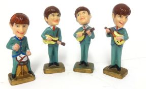 Four small, plastic figures of 'The Beatles'