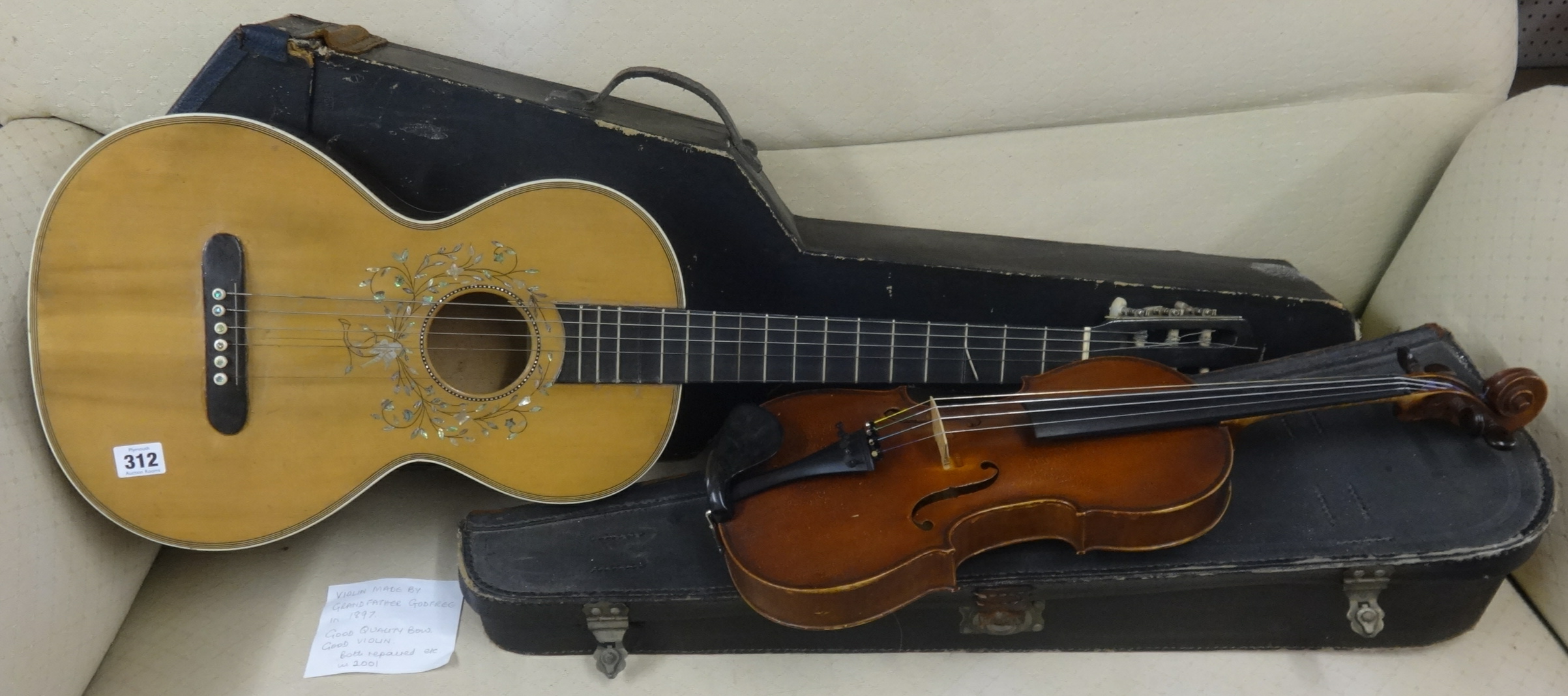 A six string classical guitar and case together with an old violin, reputedly made by the owners