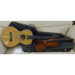 A six string classical guitar and case together with an old violin, reputedly made by the owners