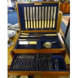 An antique oak cutlery box with brass recess military handles, with some silver plated cutlery.
