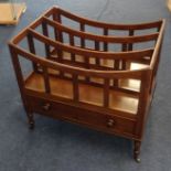 A late Georgian mahogany three division Canterbury, fitted with a single drawer on four ring