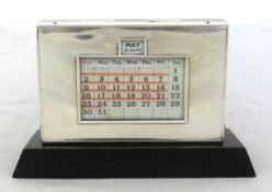 A silver framed perpetual calendar.