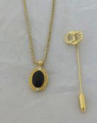 A Christian Dior oval black enamelled pendant and necklace and stick pin in original box.