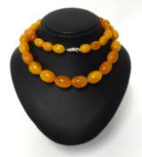 An amber bead necklace, length 62cm, approx 80gms and a pair of earrings.