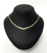 An impressive diamond line necklace, set in 14k yellow gold with 131 round cut diamonds, assessed