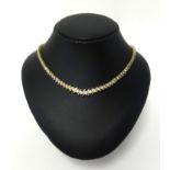 An impressive diamond line necklace, set in 14k yellow gold with 131 round cut diamonds, assessed