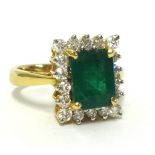 An 18ct fine emerald and diamond ring cluster ring, the oblong step cut emerald approx 2.60cts,