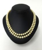 A good double row pearl necklace the clasp set with two diamonds old cut in yellow gold.