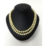A good double row pearl necklace the clasp set with two diamonds old cut in yellow gold.