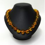 An amber necklace, set with 35 graduated beads, approx 52gms.