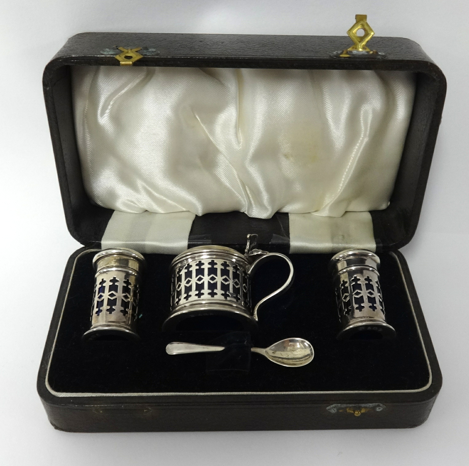 A Geo V four piece silver condiment set in fitted case, each fitted with blue glass liner.