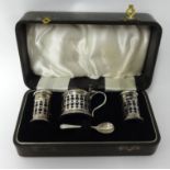 A Geo V four piece silver condiment set in fitted case, each fitted with blue glass liner.