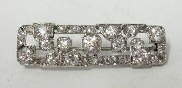 A fine art deco platinum and diamond bar brooch set with an arrangement of round old cut diamonds,