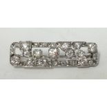 A fine art deco platinum and diamond bar brooch set with an arrangement of round old cut diamonds,