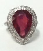 A 14k white gold and diamond ring set with a pear cut ruby (approx 7.50 carats), finger size N.