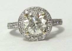 A fine 18ct diamond ring of halo design the centre stone approx 1.50ct with further diamonds to