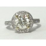 A fine 18ct diamond ring of halo design the centre stone approx 1.50ct with further diamonds to