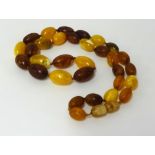 An amber necklace, various colours, 31 beads, approx 20gms.