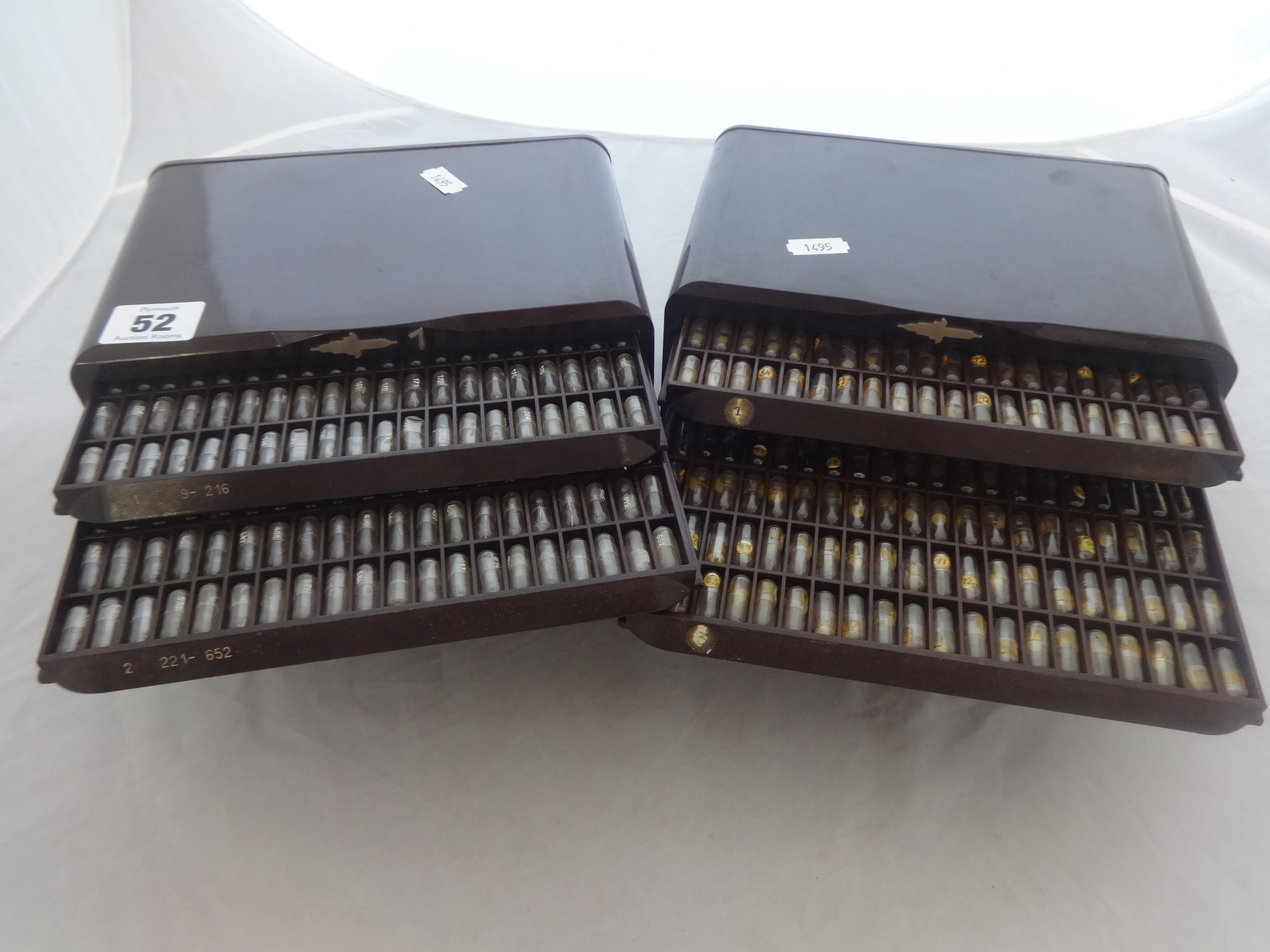 Two bakelite sets of drawers with various small watch parts.