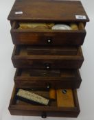 A small chest fitted with four drawers, various watchmaker components and small boxed tool set, U