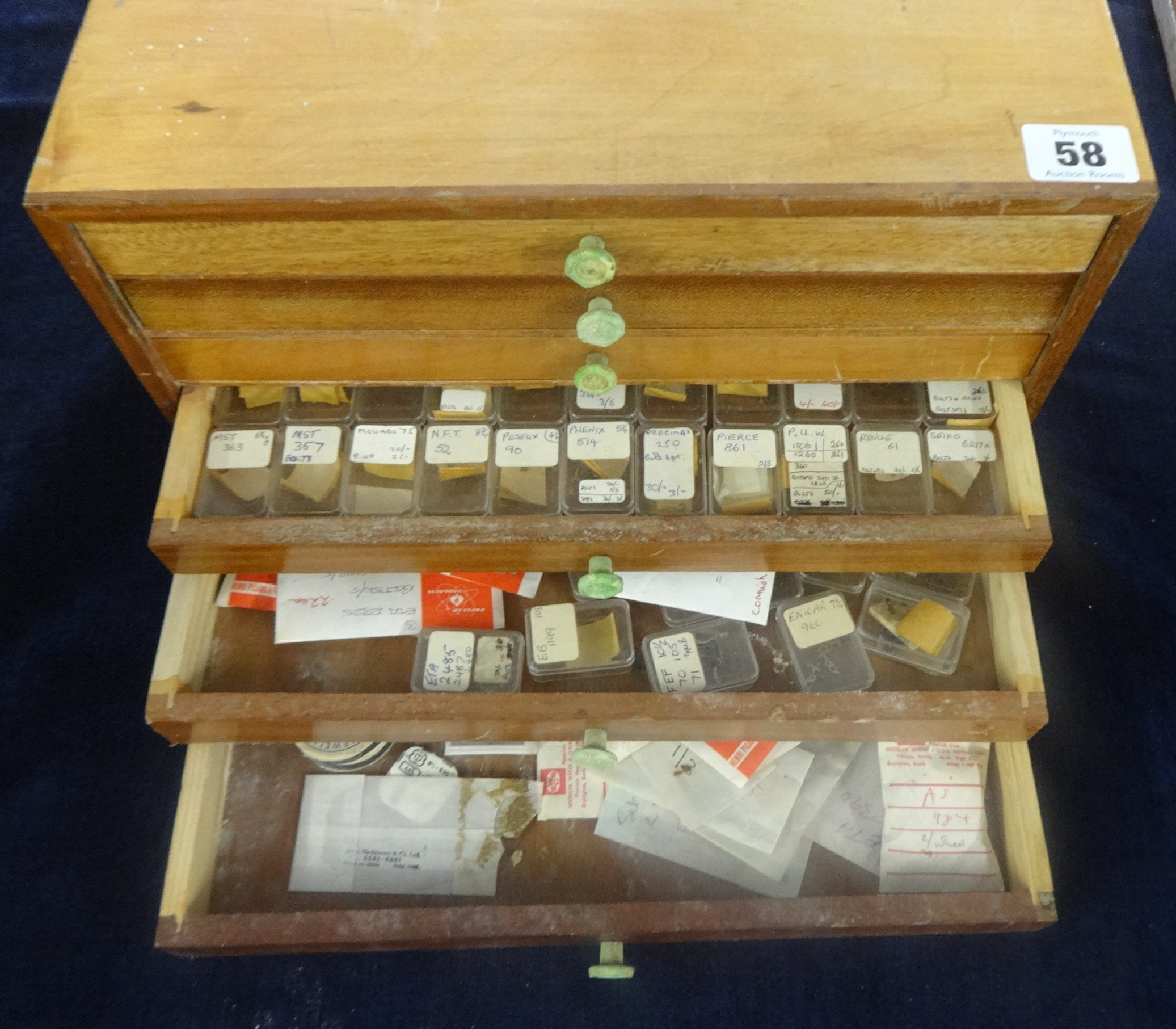 A small chest fitted with 6 drawers of very small watch parts, annotated, etc.