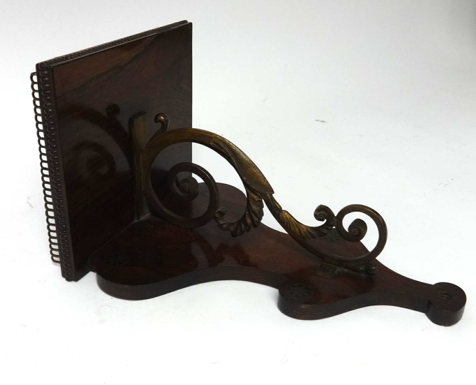 A Regency rosewood and brass inlaid clock bracket with a pierced gilt gallery.