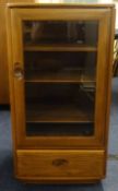 Ercol, a glass fronted cabinet.