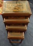 A nest of four carved oriental tables, the smallest one fitted with a drawer.
