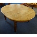 A Victorian light oak dining table with extending movement to accommodate five small size leaves,