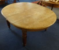 A Victorian light oak dining table with extending movement to accommodate five small size leaves,