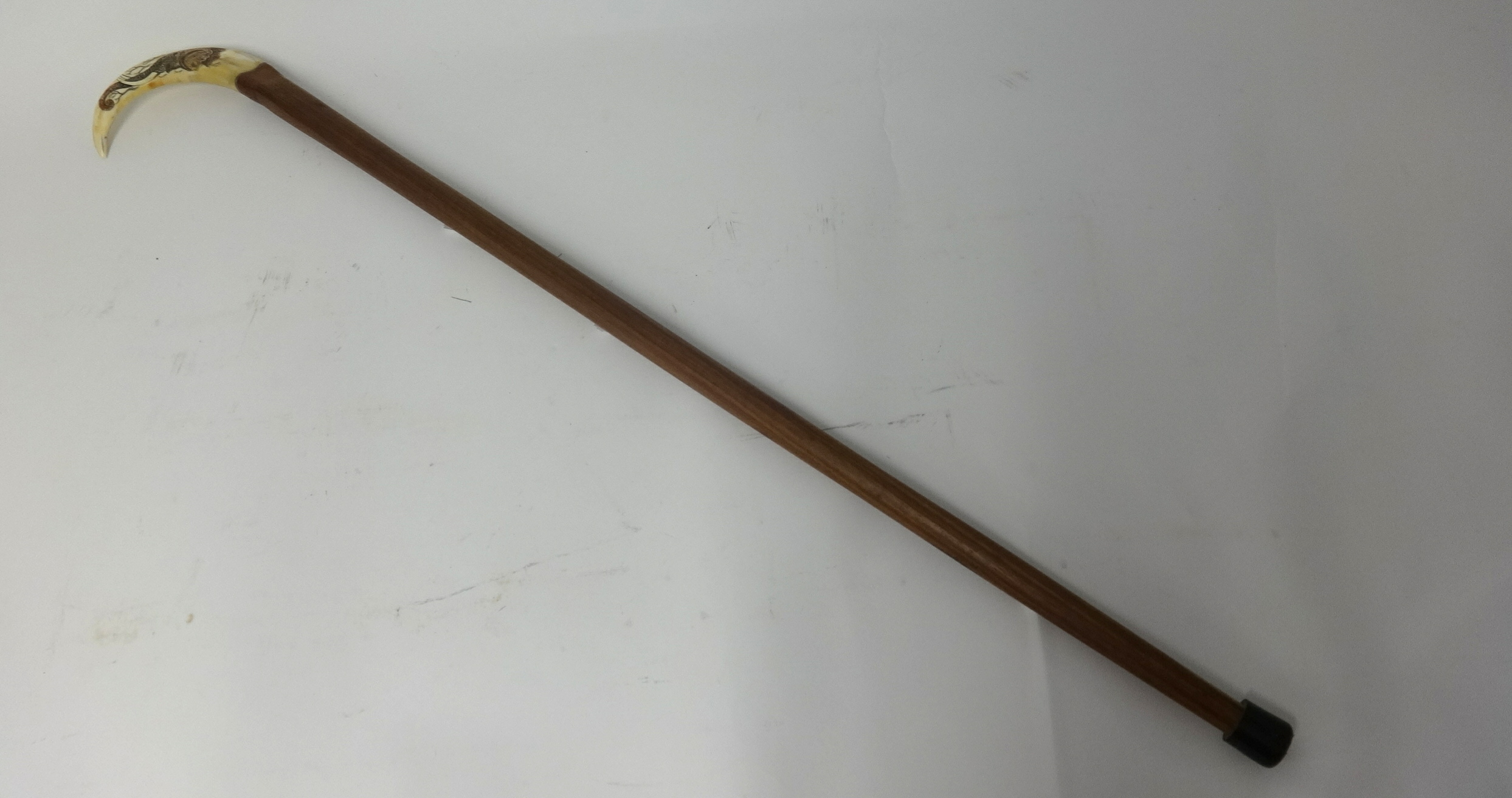 A walking cane with 'scrimshaw' handle and another carved ivory cane (2)