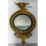A reproduction gilt framed convex mounted surmounted with an eagle, overall height 90cm