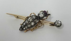 An antique bug brooch, set with old cut diamonds and ruby's in yellow gold, length 30mm.