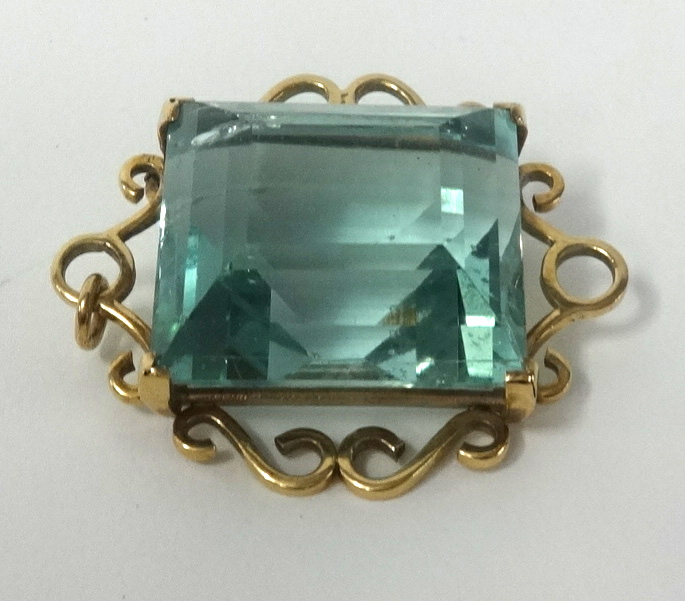 A large aqua marine brooch pendant set in gold, approx 56cts.