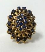 A large 9ct gold and sapphire cluster ring, finger size L, approx 7.3gms.